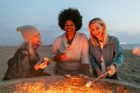 A group gathered around a fire pit outdoors at dusk